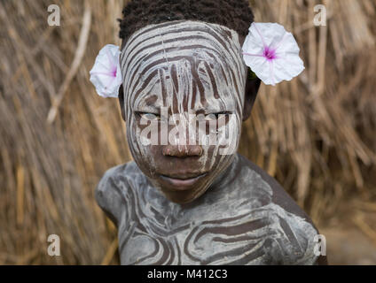 Mursi Stamm Junge trug Make-up und Blumen, Omo Valley, Mago National Park, Äthiopien Stockfoto