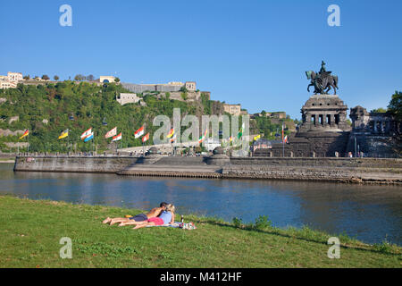 Paar auf Rasen, Deutsche Eck (Deutsches Eck), Imperial Wilhelm Statue, hinter der Festung Ehrenbreitstein, Koblenz, Rheinland-Pfalz, Deutschland, Europa Stockfoto