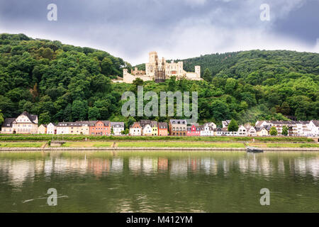 Kleines Dorf am Rhein in der Nähe von Koblenz, Deutschland mit dem Schloss Stolzenfels im Hintergrund. Stockfoto