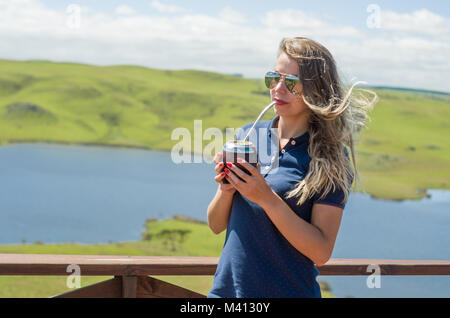 Junge Frau trinkt Chimarrão (mate) mit einer wunderschönen Aussicht Stockfoto