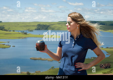 Junge Frau trinkt Chimarrão (mate) mit einer wunderschönen Aussicht Stockfoto