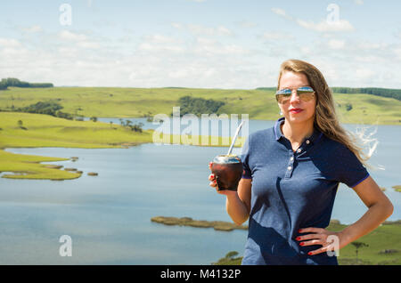 Junge Frau trinkt Chimarrão (mate) mit einer wunderschönen Aussicht Stockfoto