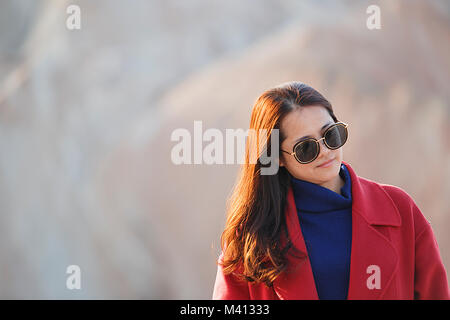 Zhangye, China - Oktober 15,2017: Schöne chinesische Touristen stellt für Ihr Partner mit einem schönen roten Mantel im Inneren der geologische Park von Zanghye Danxia in China Stockfoto