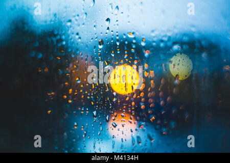 Regen fällt auf Fenster. Ruhigen Abend oder in der Nacht zu Hause, wenn draussen geregnet. Wassertropfen auf Glas. Oberfläche der nassen Glas. Wasser spritzen. City lights Bo Stockfoto