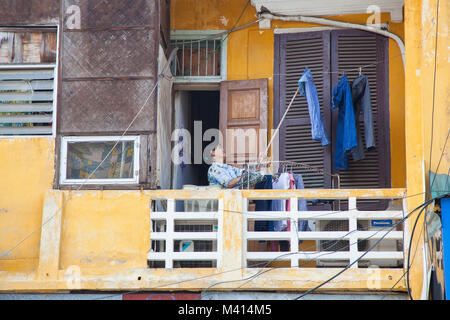 Lokale Frau vor ihrem Haus in Hanoi, Vietnam hängende Wäsche und Kleidung zu trocknen auf dem Balkon Stockfoto