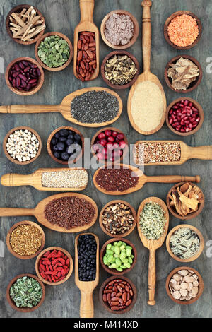 Gesunde Ernährung Essen Konzept mit Hülsenfrüchte, Obst, Getreide, Getreide, Kräuter und Gewürze auf Marmor in hölzernen Schüsseln und Löffel. Nahrungsmittel im o Stockfoto