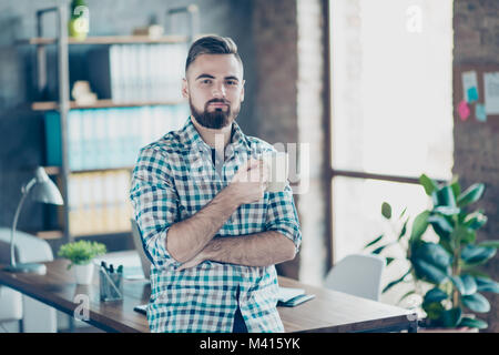 Kaffee - Zeit bei der Arbeit. Portrait von zufriedenen herrliche zuversichtlich Arbeitgeber trinken heiße frische aromatische Latte im Büro Stockfoto