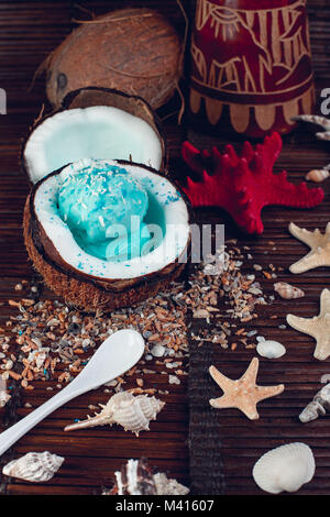 Blue Ice Cream Coconut Schüssel in der Nähe von Sand, Muscheln, Seesterne. Stockfoto