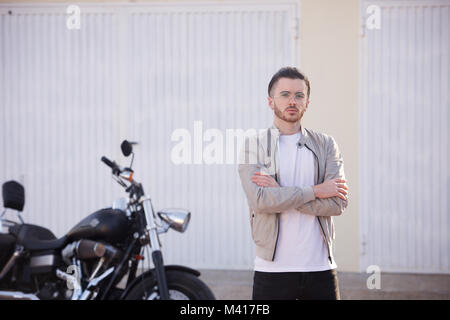 Junger Mann mit einem Bart trug ein weißes T-Shirt und eine Harley Davidson Motorrad Stockfoto