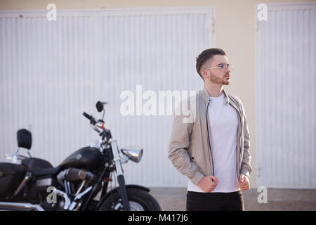 Junger Mann mit einem Bart trug ein weißes T-Shirt und eine Harley Davidson Motorrad Stockfoto