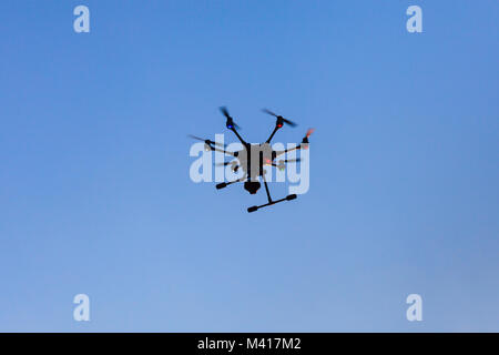 Drone schwebt gegen den klaren blauen Himmel Stockfoto