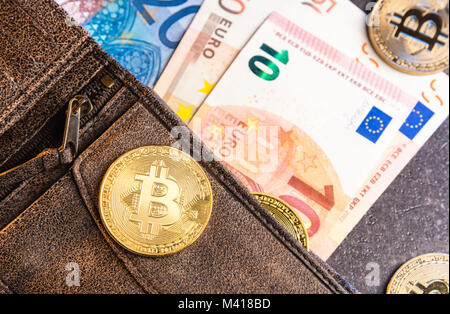 Bitcoins und Euro-banknoten im Lederetui Stockfoto