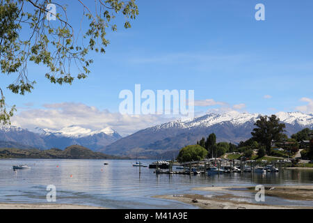 Blick von Wanaka, Südinsel, über Roys Bucht am südlichen Ende des Lake Wanaka auf Schnee bedeckte Berge auf South Island, Neuseeland. Stockfoto