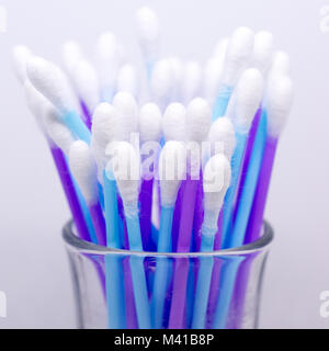 Aufrechte lila und blau Wattestäbchen in einem kleinen Glas. Stockfoto