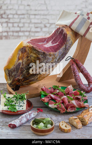 Jamon. Jamon Serrano. Traditionelle spanische Schinken hautnah. Trocken spanische Schweinefleisch Schinken in eine Platte geheilt. Alte vintage Holz- Hintergrund Stockfoto