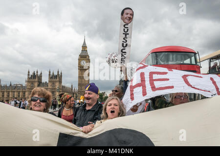 Eine Frau hält ein Plakat mit einem Bild von George Osbone und das Wort 'CUTSUCKER' mit zwei Ballons hinter der DPAC-Banner Blockieren von Verkehr auf die Westminster Bridge auf den Haushalt Tag aus Protest gegen Kürzungen schlagen der deaktiviert. Stockfoto