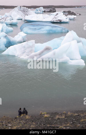 Paar beobachten Gletscher Eisberge in Jokulsarlon Lagune Island Stockfoto