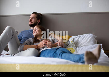 Junges Paar mit Tee im Bett Stockfoto