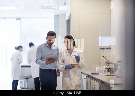 Weibliche Wissenschaftler diskutieren, Ergebnisse von Experiment mit männlichen Kollegen Stockfoto
