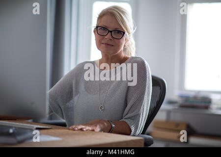 Portrait von Reife geschäftsfrau am Schreibtisch Stockfoto