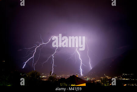 Ein starkes Gewitter viele Blitze auf dem Meran Stadt entladen, während der Nacht. Passeiertal, Trentino-Südtirol, Italien Stockfoto