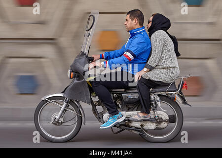 Teheran, Iran - 28. April 2017: eine Frau im Kopftuch sitzt hinter einem motorradfahrer unterwegs auf der Autobahn, Kamera das Panning für Bewegungsunschärfe in Backgr Stockfoto