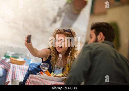 Junges Paar Essen im Freien unter einem selfie Stockfoto