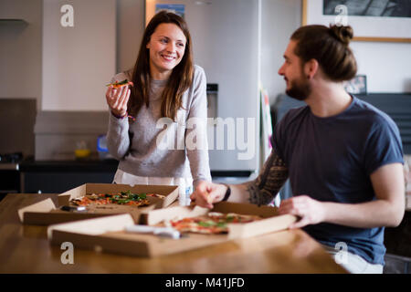 Junges Paar essen Pizza zum Mitnehmen zu Hause Stockfoto