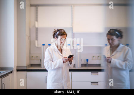 Wissenschaftlerin mit im Labor smartphone Stockfoto