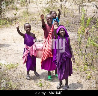 Afrika, Tansania - Februar 9, 2014: Portrait auf einer afrikanischen Kinder der Massai Stamm Dorf lächelnd in die Kamera, das Leben in Haus mit Kuhmist, Fe Stockfoto