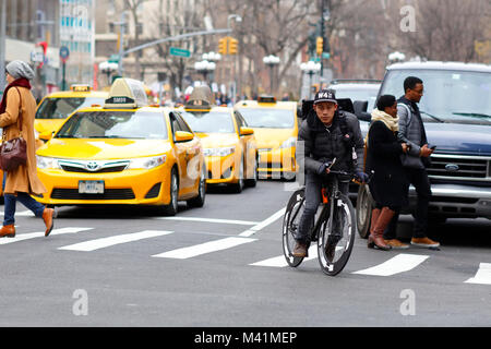 Ein fahrradkurier aus new york city auf den Straßen von Manhattan mit gelben Taxis im Hintergrund. 17. Januar 2018 Stockfoto