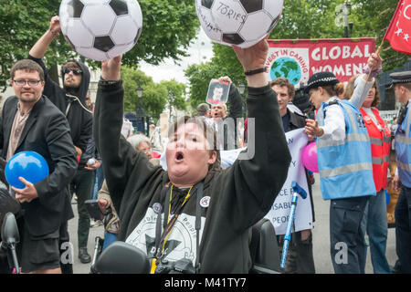 Paula Peters der DPAC-hält zwei Fußbälle mit Nachrichten für die GOVERNENT an behinderte Menschen gegen Kugeln Schnitte" zu protestieren, den Haushalt "außerhalb der Downing St. Stockfoto