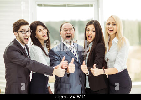 Konzept der Erfolg im Geschäft: Der Boss und triumphierend Business Team machen die Geste Daumen hoch Stockfoto