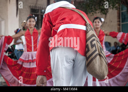 Ein Mann, der traditionelle rote und weiße Kleidung tanzen mit zwei Frauen Kleider tragen bei Barranquilla Karneval Stockfoto