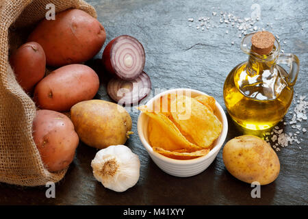 Kartoffeln mit Chips, roten Zwiebeln, Olivenöl, Knoblauch und Salz, auf schiefer Tisch mit Platz kopieren Stockfoto