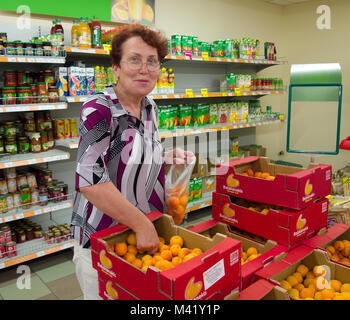 Voronezh, Russland - Juni 20, 2013, reife Frau Pfirsiche in Supermarkt wählt Stockfoto