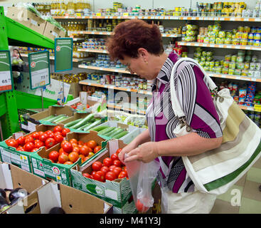 Voronezh, Russland - Juni 20, 2013, reife Frau entscheidet, Tomaten im Supermarkt Stockfoto