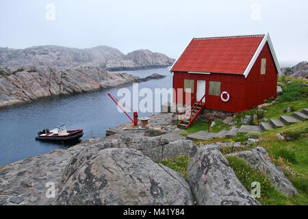 Ein Bild von einem traditionellen roten Holzhaus am Ufer des Norwegen von Lindesnes. Stockfoto