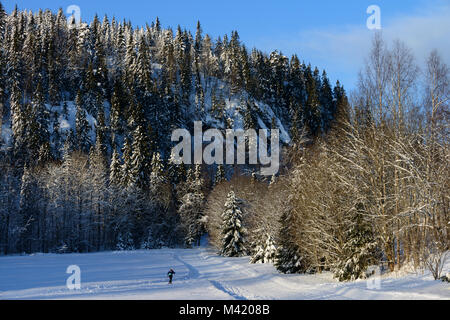 Seine Stille früh an diesem schönen Morgen, wenn die Sonne beginnt, sich die Schatten und dieser Skifahrer Köpfe heraus in die Berge zu fahren. Blauer Himmel die minus 10. Stockfoto
