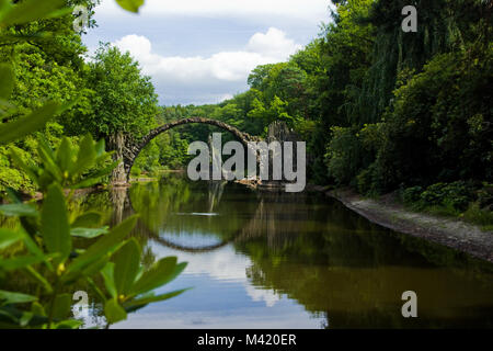 Eine romantische Devils Bridge aus Steinen in einem Park in Deutschland. Stockfoto