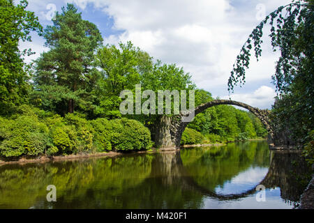 Eine romantische Devils Bridge aus Steinen in einem Park in Deutschland. Stockfoto