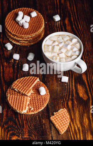 Hausgemachte holländischen Waffeln mit Zerbrochenen mit weißen Tasse Kakao mit Marshmallow und Waffel Stack. Vertikale Ausrichtung. Stockfoto