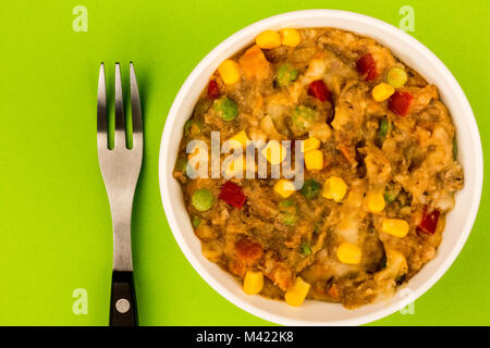 Traditionelle Shepards Pie und Gemüse in eine Schüssel vor einem grünen Hintergrund Stockfoto