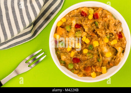 Traditionelle Shepards Pie und Gemüse in eine Schüssel vor einem grünen Hintergrund Stockfoto