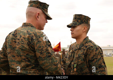 Brig. Gen. Daniel B. Conley, Links, Kommandierender General, 3. Marine Logistik Gruppe, präsentiert Sgt. Heriberto Navarro, der Leiter der Zentrale und Service Unternehmen, 3. Transport Support Battalion, 3. Marine Logistik Gruppe, mit dem Preis für die III Marine Expeditionary Force Noncommissioned Officer des Jahres im Camp Foster, Okinawa, Japan, 8. Februar, 2018. Navarro wurde als die III MEF NCO des Jahres geehrt für sein vorbildliches bei der Wahrnehmung seiner Aufgaben, die Verwaltung von etwa $ 250.000 Wert von Inventar und Ausrüstung während Koreanische Marine Exchange Programm 18.1, sowie seine Leistung ein Stockfoto