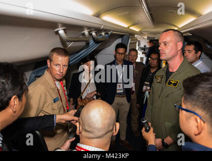 180208-N-FV 739-070 CHANGI, Singapur (Feb. 8, 2018) - Lt.Cmdr. Arlo Abrahamson, Public Affairs Officer von Commander, Logistik Gruppe Western Pacific, und Lt.Cmdr. Karl Murray, Offizier der Patrol Squadron (VP) 8, Platz, um ein Medium zu Anfrage von einem P-8A Poseidon bei einem Rundgang auf der Singapore Air Show in Changi Exhibition Centre. Die Show war eine Gelegenheit für die USA flexible Bekämpfung Fähigkeiten zu zeigen und Gegner abzuschrecken, die gleichzeitig Verbündeten und Partnern. (U.S. Marine Foto von Mass Communication Specialist 3. Klasse Christopher A. Veloicaza) Stockfoto