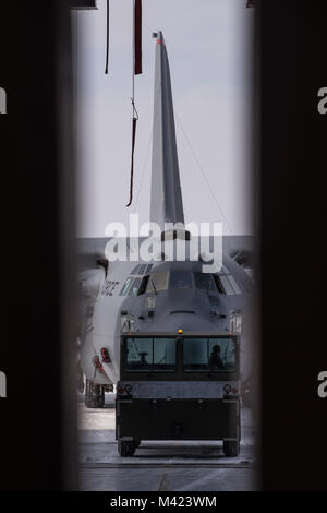 Flieger guide C-130H Hercules in den Hangar ein isochroner Inspektion der vor kurzem erworbenen Flugzeuge, zu beginnen, 08.02.2018, an der 179th Airlift Wing, Mansfield, Ohio. Schwanz 666 wurde vor Kurzem von Yakota Airbase, Japan übertragen werden, und wird die Mansfield schwanz Markierungen während der ISO-Prozess, der eine umfangreiche Auswertung der ganzen Maschine einwandfreie Funktionalität und Mission Bereitschaft zu gewährleisten. (U.S. Air National Guard Foto von Tech. Sgt. Joe HarwoodReleased) Stockfoto