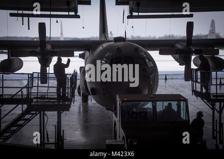 Flieger guide C-130H Hercules in den Hangar ein isochroner Inspektion der vor kurzem erworbenen Flugzeuge, zu beginnen, 08.02.2018, an der 179th Airlift Wing, Mansfield, Ohio. Schwanz 666 wurde vor Kurzem von Yakota Airbase, Japan übertragen werden, und wird die Mansfield schwanz Markierungen während der ISO-Prozess, der eine umfangreiche Auswertung der ganzen Maschine einwandfreie Funktionalität und Mission Bereitschaft zu gewährleisten. (U.S. Air National Guard Foto von Tech. Sgt. Joe HarwoodReleased) Stockfoto