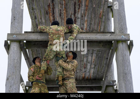 Soldaten in die 3 Assault Helicopter Bataillon zugeordnet, 227 Aviation Regiment, 1 Air Cavalry Brigade, 1.Kavallerie Division, arbeiten zusammen, um ein Hindernis während des Bataillon Sporn Fahrt am Oberdachstetten Ausbildung Bereich außerhalb von Illesheim, Deutschland, Feb 2, 2018 klettern. Fahrten Stichleitungen eine altehrwürdige Tradition der Kavallerie Einheiten, die Kraft und der Charakter der Soldaten Test beim Aufbau der Kameradschaft und Esprit de Corps. (U.S. Armee foto Sgt. Gregory T. Sommer/22 Mobile Public Affairs Abteilung) Stockfoto