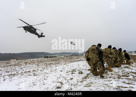 Troopers der 3 Assault Helicopter Bataillon, 227 Aviation Regiment, 1 Air Cavalry Brigade, 1.Kavallerie Division, warten Sie ein UH-60 Blackhawk Hubschrauber Board nach einem Fußmarsch während des Bataillon Sporn Fahrt am Oberdachstetten Ausbildung Bereich außerhalb von Illesheim, Deutschland, Feb 2, 2018. Der Sporn, einer anstrengenden 24-stündigen Veranstaltung, dass die Tests, die mentale und physische Zähigkeit Soldaten, ehrt die Abstammung der Kavallerie Einheiten in der Armee und nach Abschluss der Veranstaltung, Soldaten, die ihr Recht auf Dawn verdienen Sporne auf ihre Stiefel. (U.S. Armee foto Sgt. Gregory T. Sommer/22 Mobile Pu Stockfoto